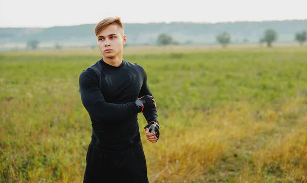 Joven Entrenando Bosque Durante Hora Dorada Estirando Midiendo Pulso Mientras —  Fotos de Stock