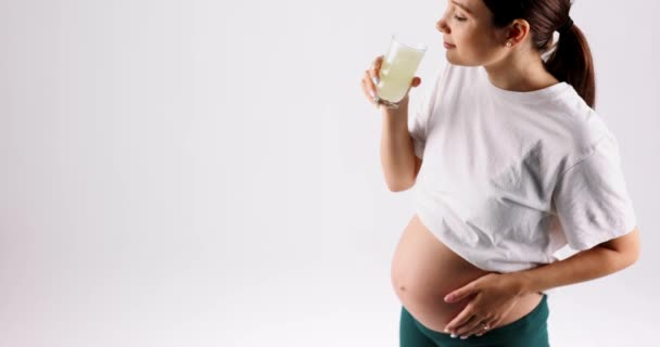 Zwangere Vrouw Drinkt Glas Water Heeft Een Wit Shirt Streelt — Stockvideo