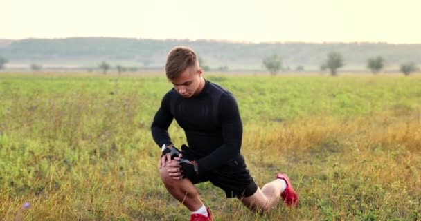 Uomo Atletico Allena All Aperto Facendo Esercizi Stretching Sullo Sfondo — Video Stock