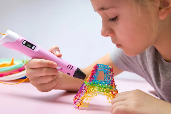 Gri tişörtlü kız 3D renkli bir kule yapıyor..