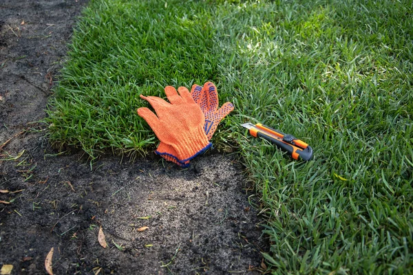 Concept Werkhandschoenen Een Gazon Knipmes Liggen Een Rolgazon — Stockfoto