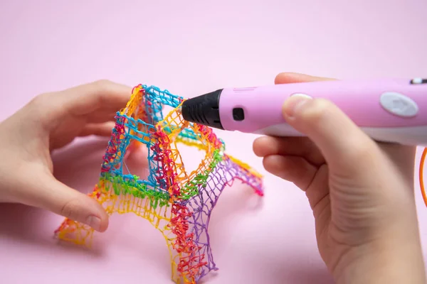 3D yazdırma kalemi, renkli oyuncakları tutan eller