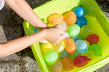 çocuk renkli balon su bombalarıyla oynuyor