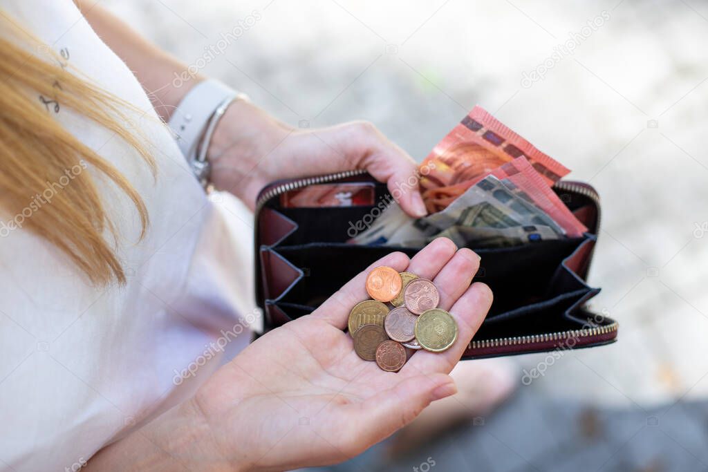 person holding a wallet with money,  women counting  coins