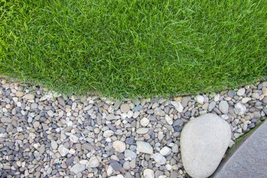 The lawn is separated by border tape and pebbles of different sizes.