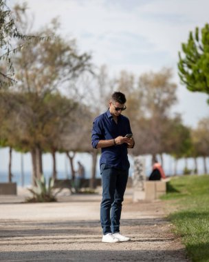 Güzel ve çekici orta yaşlı bir adam Lizbon nehri boyunca tek başına yürüyor ve akıllı telefonu kullanıyor. Resmi kıyafetler giyen klas genç bir girişimci. Başarılı yaşam tarzı kavramı