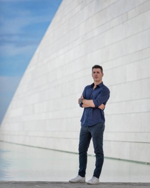 Portekiz, Lizbon 'daki Tejo nehir kenarı boyunca poz veren güzel bir gencin portresi. Şık serbest çalışan mimar şehir merkezindeki şehir konsept binasının yakınında tek başına dinleniyor..