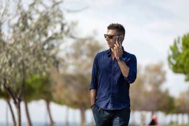 Güzel ve çekici orta yaşlı bir adam Lizbon nehri boyunca tek başına yürüyor ve akıllı telefonu kullanıyor. Resmi kıyafetler giyen klas genç bir girişimci. Başarılı yaşam tarzı kavramı