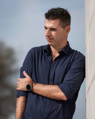 Portekiz, Lizbon 'daki Tejo nehir kenarı boyunca poz veren güzel bir gencin portresi. Şık serbest çalışan mimar şehir merkezindeki şehir konsept binasının yakınında tek başına dinleniyor..