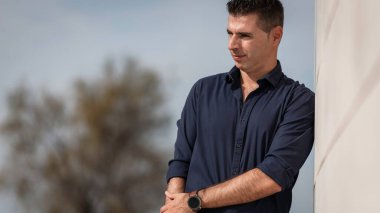 Portekiz, Lizbon 'daki Tejo nehir kenarı boyunca poz veren güzel bir gencin portresi. Şık serbest çalışan mimar şehir merkezindeki şehir konsept binasının yakınında tek başına dinleniyor..