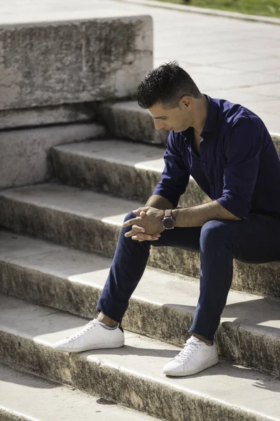 Serbest çalışan bir mimar Lizbon 'un kalbindeki beton merdivenlerde tek başına oturuyor, dinleniyor ve işe ara veriyor. Hafif bir yaz gününde resmi kıyafetler giyen klas genç girişimci.