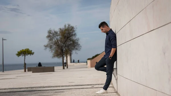 在葡萄牙里斯本 一个漂亮的年轻人在滨河边拍照时的肖像 时尚的自由建筑师一个人在市中心的城市概念大楼附近放松一下 — 图库照片