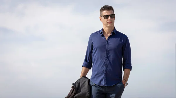 ポルトガルのリスボン川沿いでリラックスした若い上品な起業家の肖像画 ブルーのエレガントなシャツと正式な衣装を着た上品なビジネスマン 成功したライフスタイルコンセプト — ストック写真