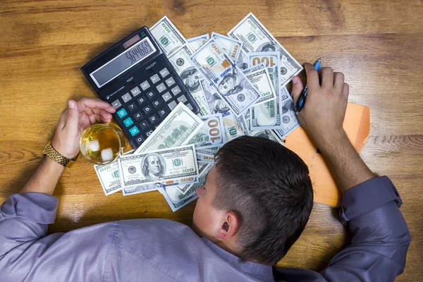 Homem adormecido perto do dinheiro com calculadora — Fotografia de Stock