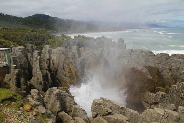 ニュージーランドのプナカイキにあるパンケーキ岩 Punakaiki近くのドロマイトポイントのパンケーキ岩は 海がいくつかの垂直のブローホールを通って破裂するひどく浸食された石灰岩地帯です — ストック写真