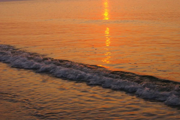 Поверхность морской воды в свете восхода солнца — стоковое фото