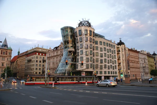 Evening street view with famous Dancing House and red trolley  in Prague — Stock Photo, Image