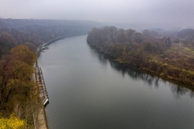 Güz yeşili nehir ve sarı park bulutlu bir sonbahar gününde İHA 'dan çekiliyor 