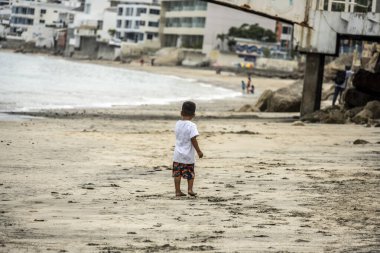 sellers of goods on the beach and vacationers on the beach near the sea in a resort in Ecuador 