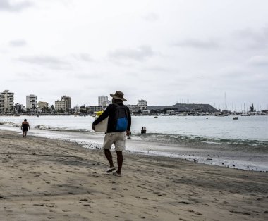 sellers of goods on the beach and vacationers on the beach near the sea in a resort in Ecuador 