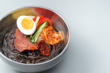 Beyaz arka planda bir kase Kore eriştesi.