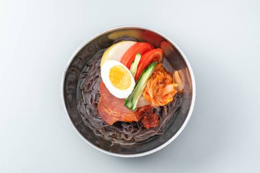 Beyaz arka planda bir kase Kore eriştesi.