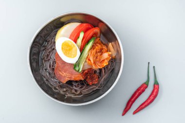 Beyaz arka planda bir kase Kore eriştesi.