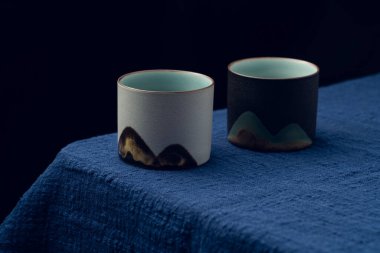 Mavi masa örtüsüne iki tane hassas çay fincanı konur.