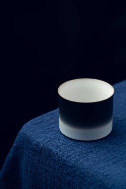 Koyu mavi masa örtüsüne hassas bir çay fincanı yerleştirildi.