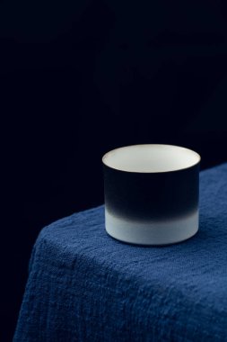 Koyu mavi masa örtüsüne hassas bir çay fincanı yerleştirildi.