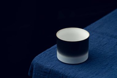 Koyu mavi masa örtüsüne hassas bir çay fincanı yerleştirildi.