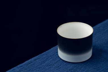 Koyu mavi masa örtüsüne hassas bir çay fincanı yerleştirildi.