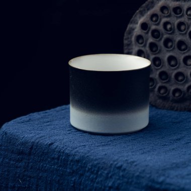 Koyu mavi masa örtüsüne hassas bir çay fincanı yerleştirildi.