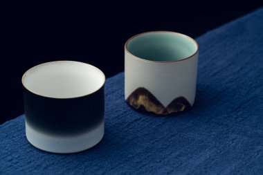 Mavi masa örtüsüne iki tane hassas çay fincanı konur.