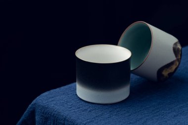 Mavi masa örtüsüne iki tane hassas çay fincanı konur.