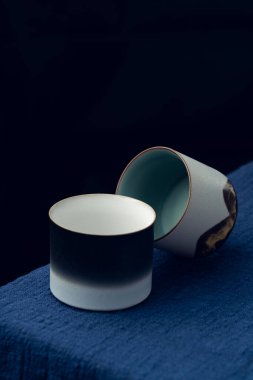 Mavi masa örtüsüne iki tane hassas çay fincanı konur.