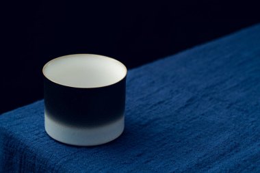 Koyu mavi masa örtüsüne hassas bir çay fincanı yerleştirildi.