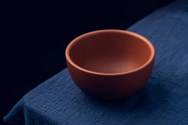 Koyu mavi masa örtüsünün üzerine mor bir kum kasesi yerleştirildi.