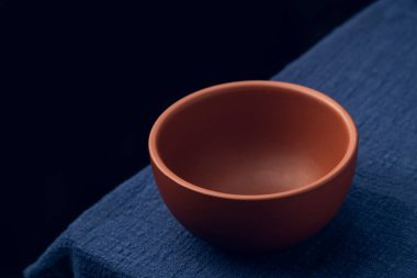 Koyu mavi masa örtüsünün üzerine mor bir kum kasesi yerleştirildi.