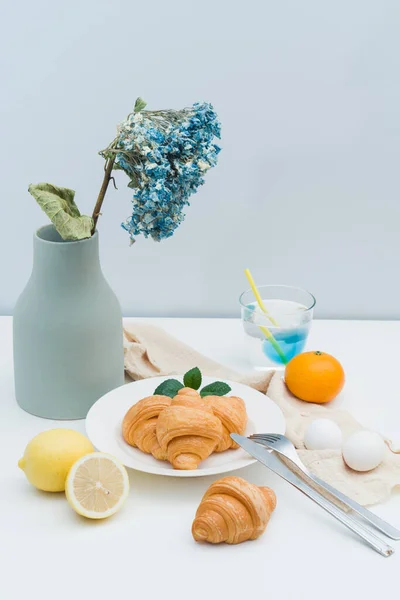 ドライフラワーの花瓶と朝食用クロワッサンのプレート — ストック写真