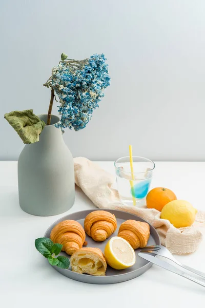 ドライフラワーの花瓶と朝食用クロワッサンのプレート — ストック写真