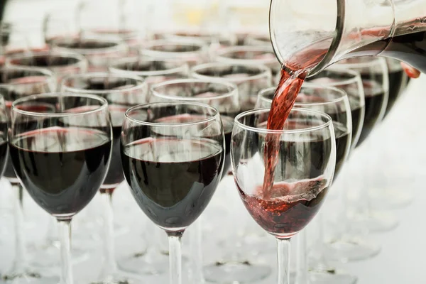 Kırmızı şarap bir bardak şarap dökme. Sığ derinlik-in tarla.