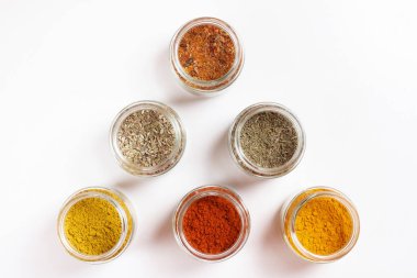 Cam kavanozlar, zerdeçal, kekik, kekik, paprika, köri, pilav. Beyazda izole edilmiş.