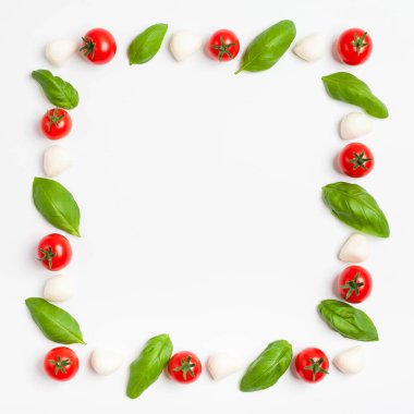 Bebek mozzarella, fesleğen yaprağı ve kiraz domatesi çerçevesi. Uzayı kopyala Üst görünüm