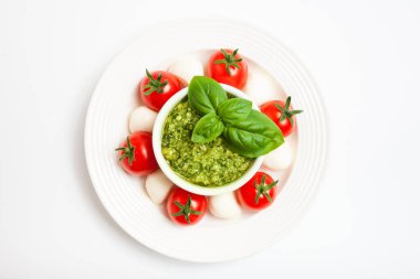 Kiraz domatesli lezzetli caprese salatası, mozzarella peyniri, pesto sosu, taze fesleğen yaprağı. İtalyan yemeği. Üst Manzara. Boş boşluk.