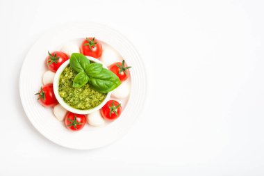 Kiraz domatesli lezzetli caprese salatası, mozzarella peyniri, pesto sosu, taze fesleğen yaprağı. İtalyan yemeği. Üst Manzara. Boş boşluk.