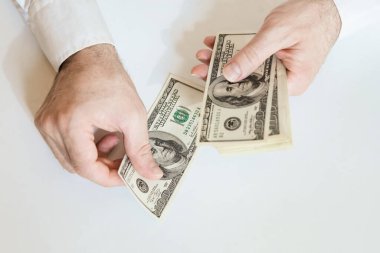 Close up of male hands counting 100 USD bills. Business, finance, economy concept.