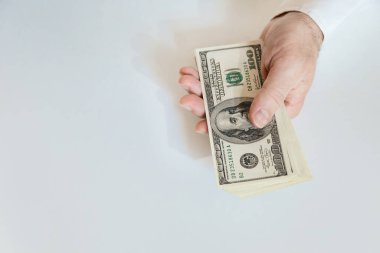 Close-up of male hands hold a stack of 100 US dollar bills. Business, finance, economy concept. Copy space.
