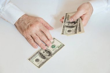 Close up of male hands counting 100 USD bills. Business, finance, economy concept.