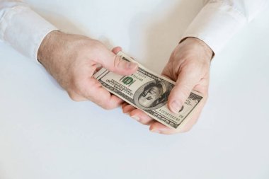 Close up of male hands hold a stack of 100 US dollar bills. Business, finance, economy concept. Top view.